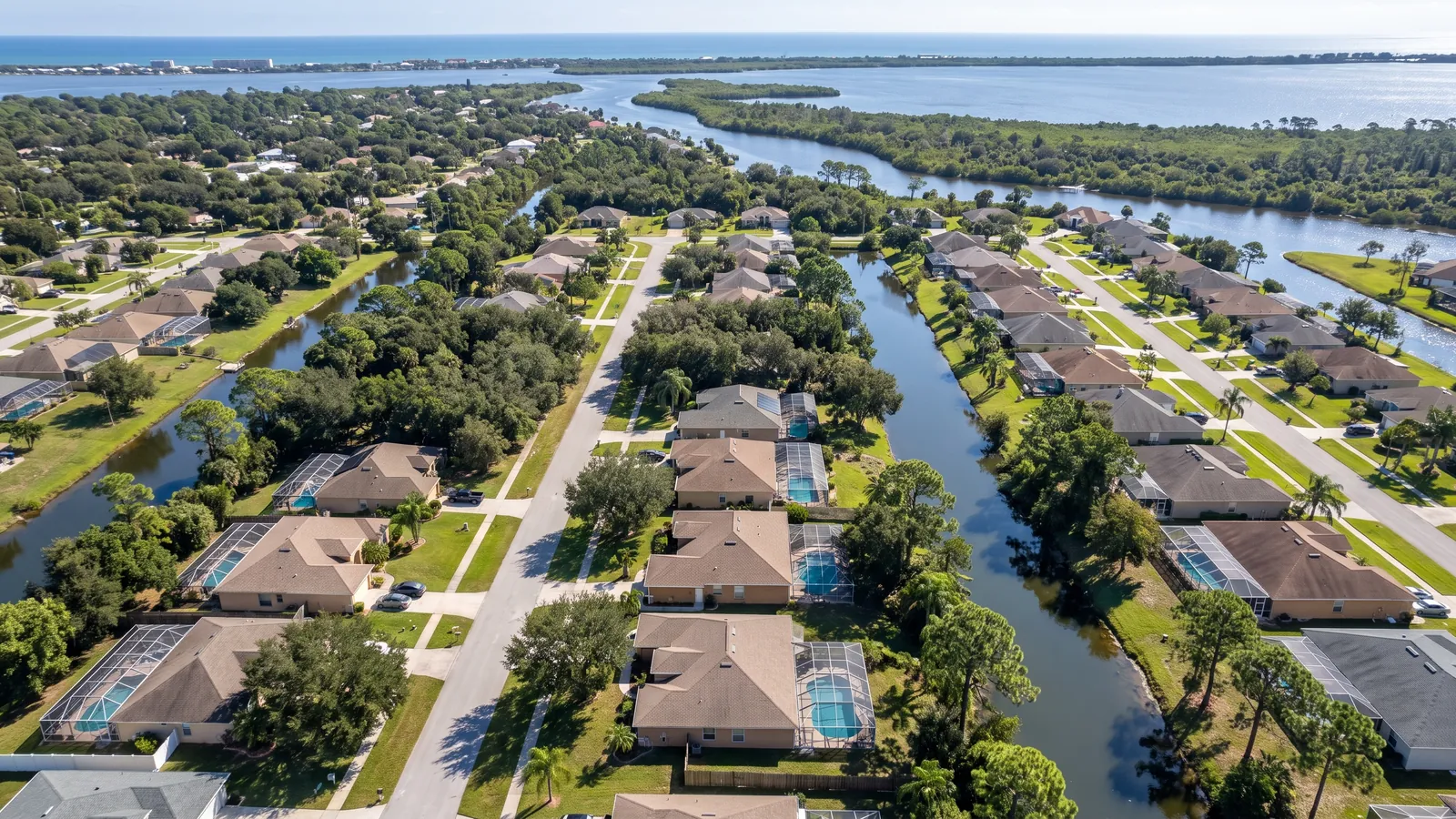 Aerial view of Palm Bay canal homes and oak canopy with Turkey Creek and the Indian River Lagoon beyond